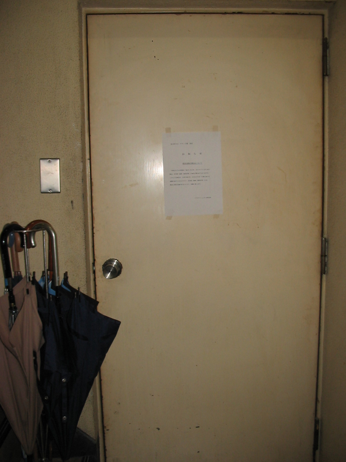 plain door with sign and umbrellas outside door