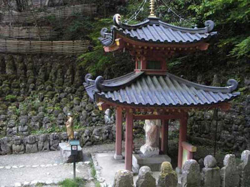 building with red roof surrounded by small statues