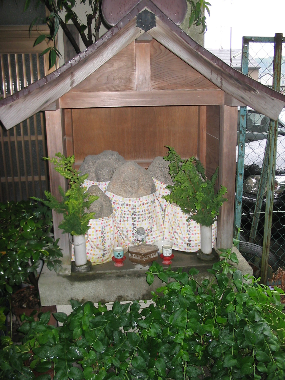 small stone statues wearing clothing with small plants