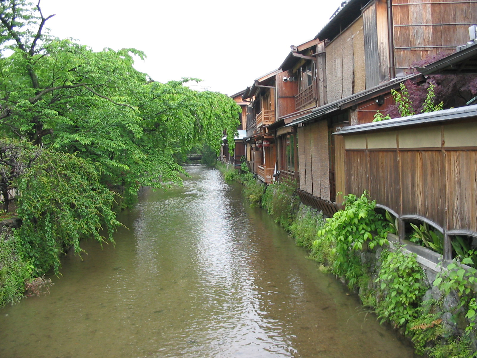 row of closed two-storey teahouses with river behind them