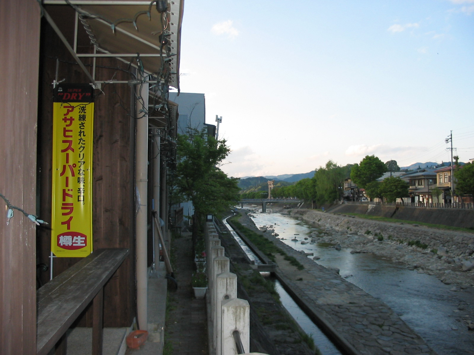 view of river from bridge with torri gate in the distance
