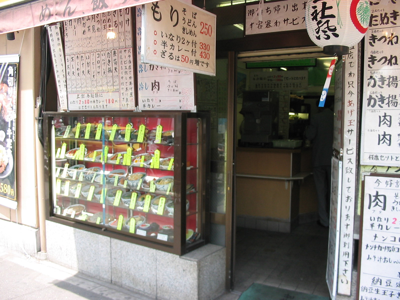 view looking into noodle restaurant where men are standing at the counter
