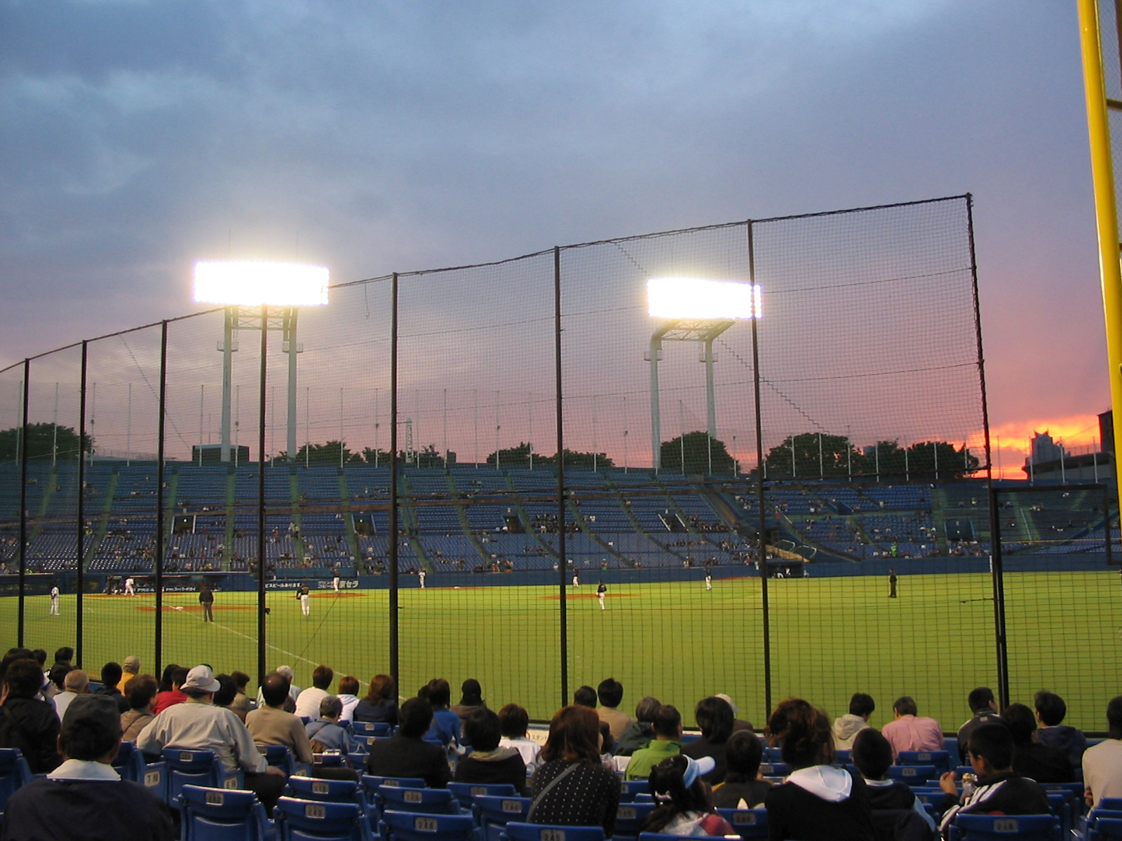 view of baseball stadium from stands with bright lights